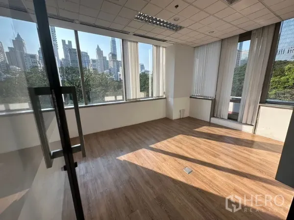 Office Space for rent - Bright private office with large corner windows, vertical blinds, wood flooring, and city and park views.