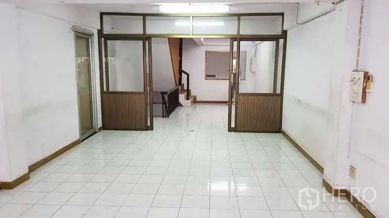 Home Office for rent or sale in Bang Na, Bangkok - Open-plan ground floor with glass partitions and a staircase.