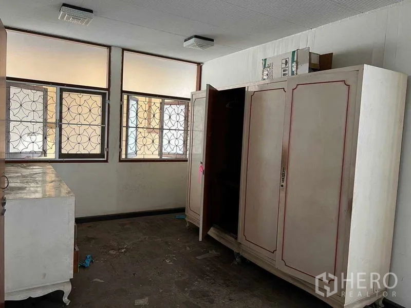 独立式住宅 出租在Sathon, Bangkok - 带复古衣柜的卧室，格栅窗采光良好。