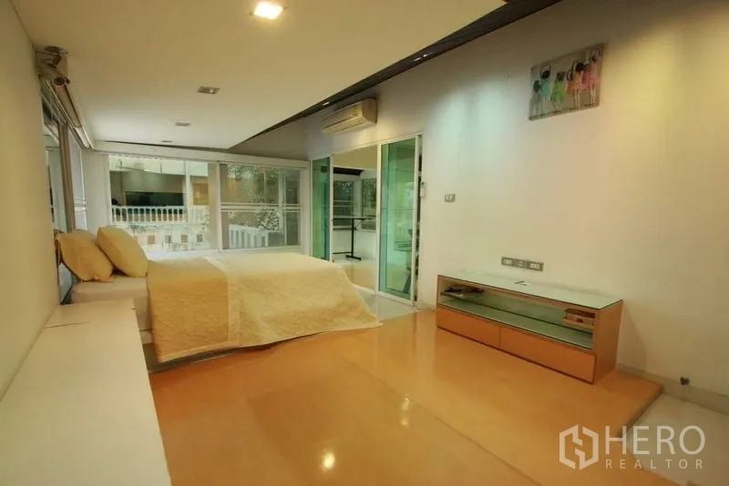 Detached House for rent in Bang Phli, Samut Prakan - Bedroom with pale wood floors, air conditioning and sliding glass doors to a balcony.