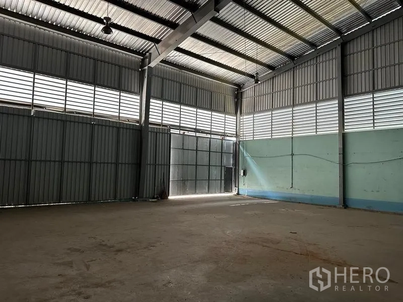 货栈 出租在Lam Luk Ka, Pathum Thani - 仓库一角，百叶窗带采光，电源接口和高大的出入口。