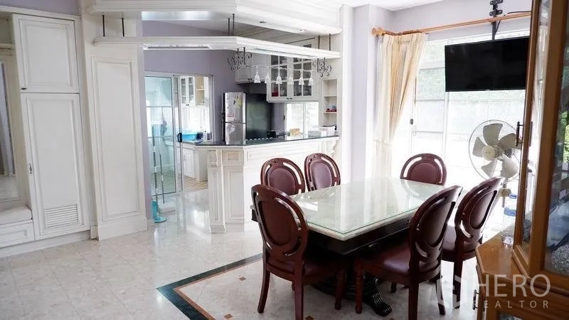 Detached House for rent in Prawet, Bangkok - Dining area for six beside an open kitchen with breakfast bar and glass doors to the garden.