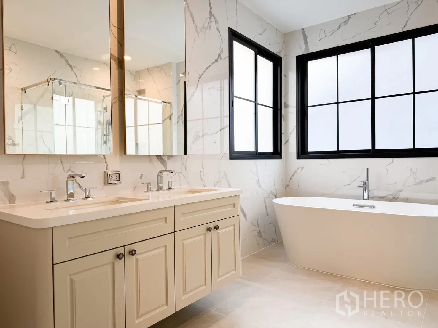 Detached House for rent in Bang Khen, Bangkok - Luxurious bathroom with double vanity, marble-effect walls and a freestanding bathtub by the window.