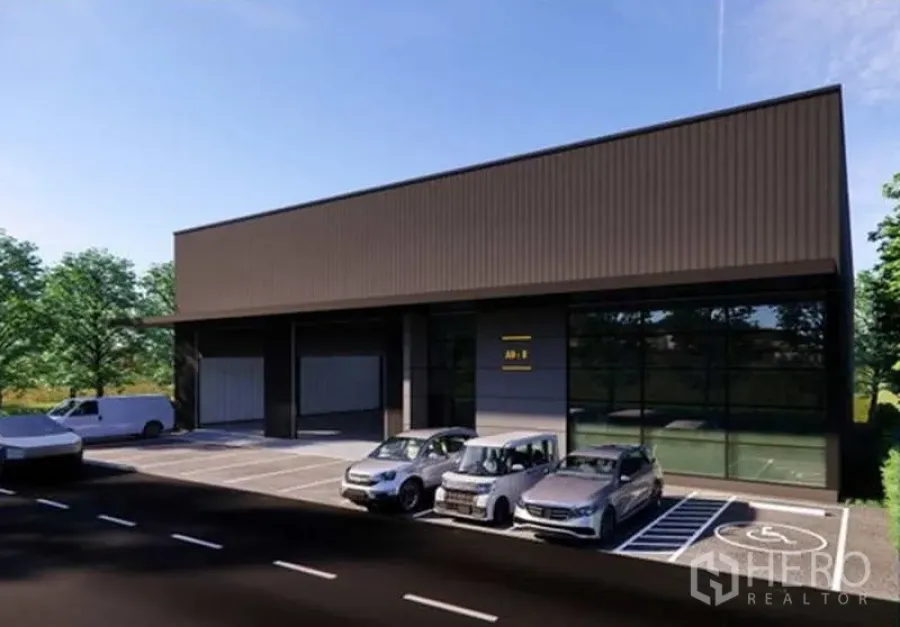 Warehouse for rent in Pak Kret, Nonthaburi - Warehouse frontage with glass office facade, marked accessible parking and several cars parked by the loading bays.