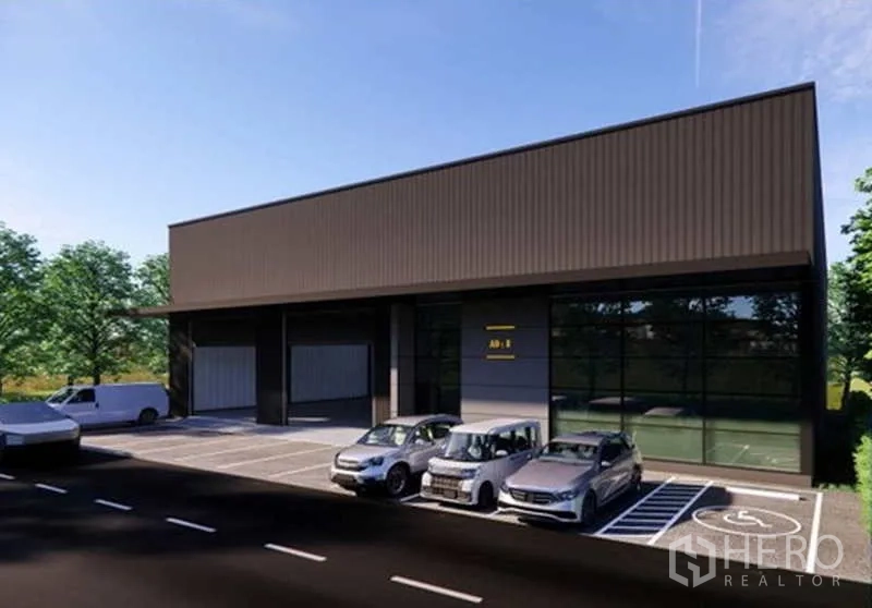 Warehouse for rent in Pak Kret, Nonthaburi - Warehouse frontage with glass office facade, marked accessible parking and several cars parked by the loading bays.