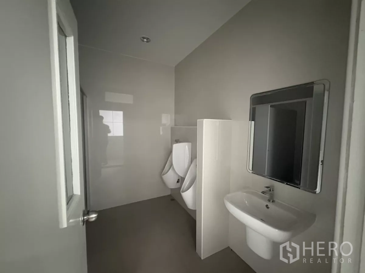 Factory for rent in Bang Phli, Samut Prakan - Clean men’s restroom with urinals, sink and mirror.