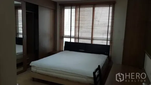 Condominium for rent in Bang Rak, Bangkok - Bedroom with queen bed, floor-to-ceiling windows with blinds, and a built-in mirrored wardrobe.