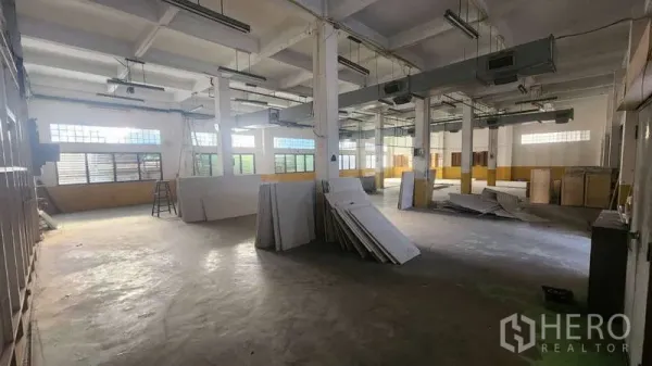 Factory for rent in Chom Thong, Bangkok - Large open production floor with columns, windows and fluorescent lighting.