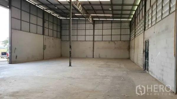 Warehouse for rent in Pathum Thani - Clear-span storage area with truss roof, high walls, and smooth concrete flooring.