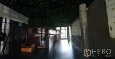 Retail Space for rent in Khlong Toei, Bangkok - Dim retail interior with bar counter, dark flooring, and leafy ceiling decor.