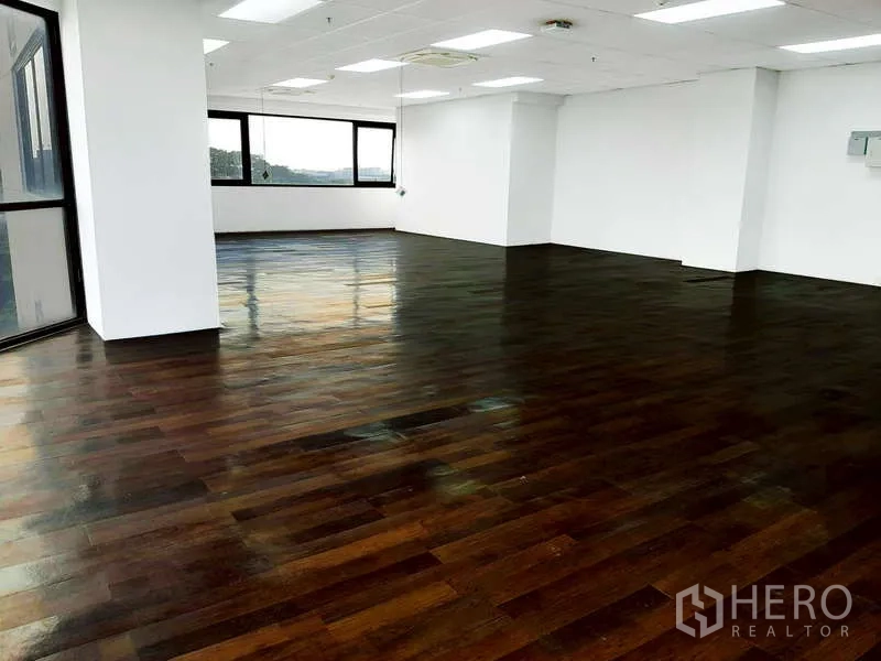 Office Space for rent - Open-plan office with polished dark wood flooring, white walls, recessed lighting and large windows.