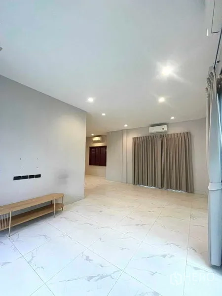 Detached House for sale in Bang Kruai, Nonthaburi - Open plan space with marble‑look tiles, air conditioning and full‑height curtains facing the garden.