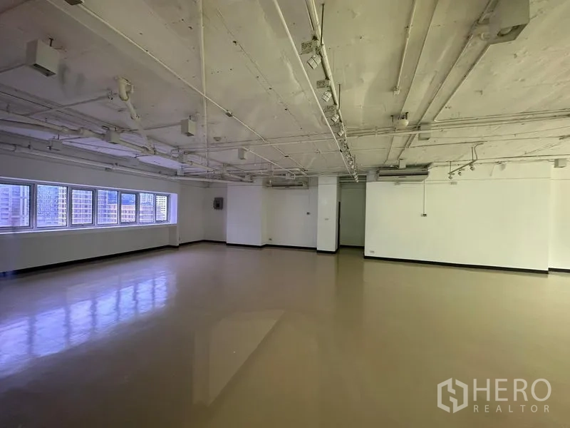 Office Space for rent in Pathum Wan, Bangkok - Spacious corner office floor plate with multiple windows, white walls and ceiling-mounted air-conditioning near BTS Chitlom.