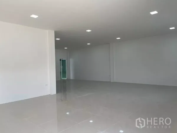 Factory for rent or sale in Bang Phli, Samut Prakan - Ground-floor office space with white walls, tiled flooring, recessed LEDs, and a glass entry door.