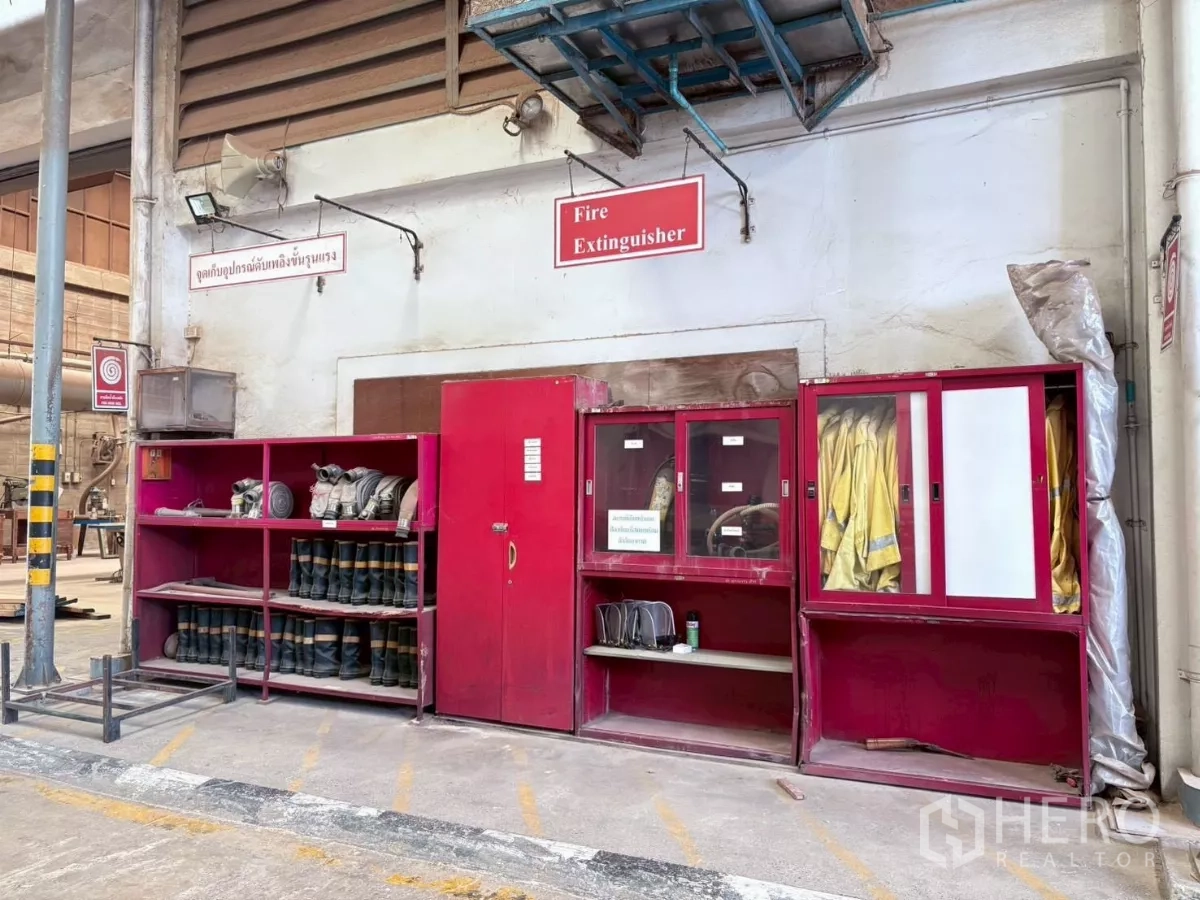 Factory for rent or sale in Bang Khun Thian, Bangkok - Wall-mounted fire safety gear cabinets with boots, jackets and equipment.