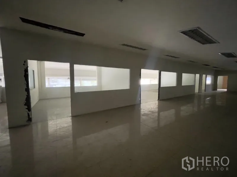 Warehouse for rent in Prawet, Bangkok - Corridor with partitioned office rooms and interior windows.