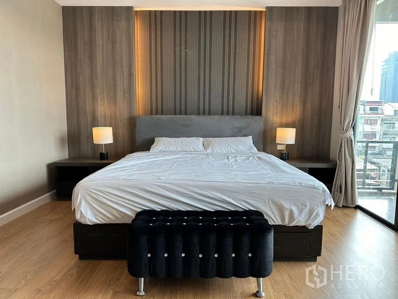 联排别墅 出租在Khlong Toei, Bangkok - 大床配特色床头板与床头灯，临近阳台。