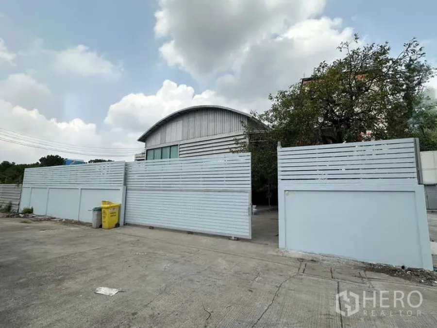 货栈 出租在Pak Kret, Nonthaburi - 独立仓库的高混凝土围墙与大门，前方宽阔混凝土场地