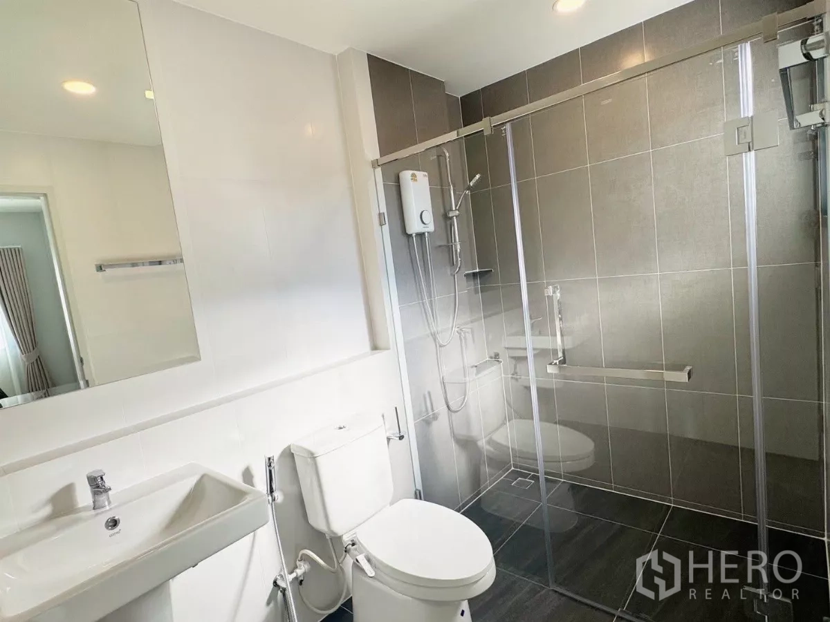 Detached House for rent or sale in Bang Phli, Samut Prakan - Shared bathroom with glass shower, water heater and modern tiles.