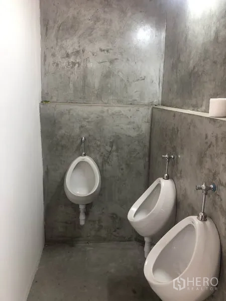 货栈 出租在Bang Yai, Nonthaburi - 男厕小便区，两个挂墙式小便器与水泥质感墙面。