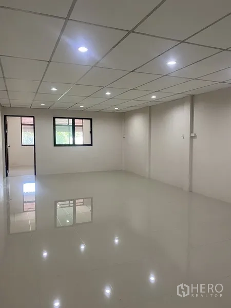 联排别墅 出租在Suan Luang, Bangkok - 宽敞卧室空间，白色亮面地砖与网格天花，双窗采光。
