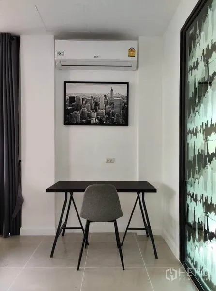 Townhouse for rent in Suan Luang, Bangkok - Compact home office nook beneath an air conditioner beside a glass door.