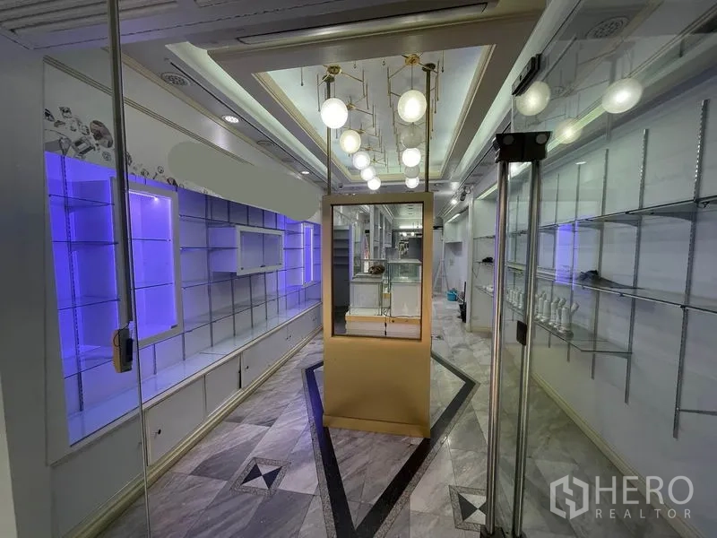 Shophouse for rent in Bang Rak, Bangkok - Central display island beneath modern globe pendant lights near the entrance.