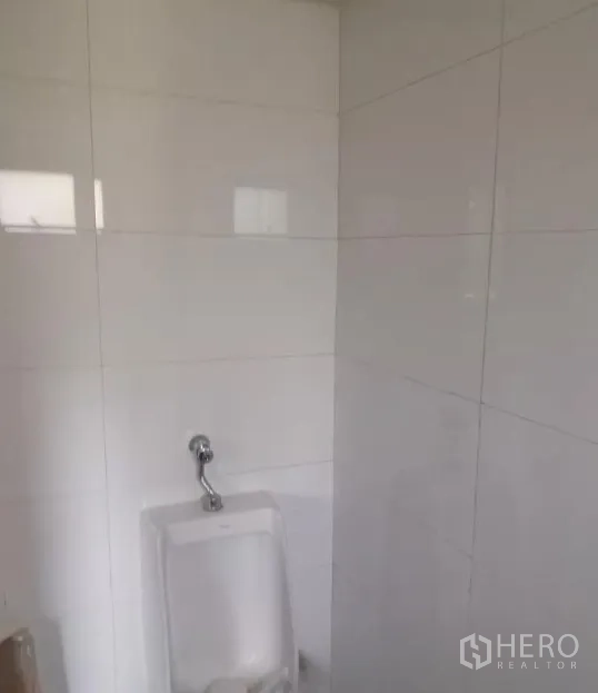 Retail Space for rent - Clean tiled restroom with a wall-mounted urinal inside the retail premises.