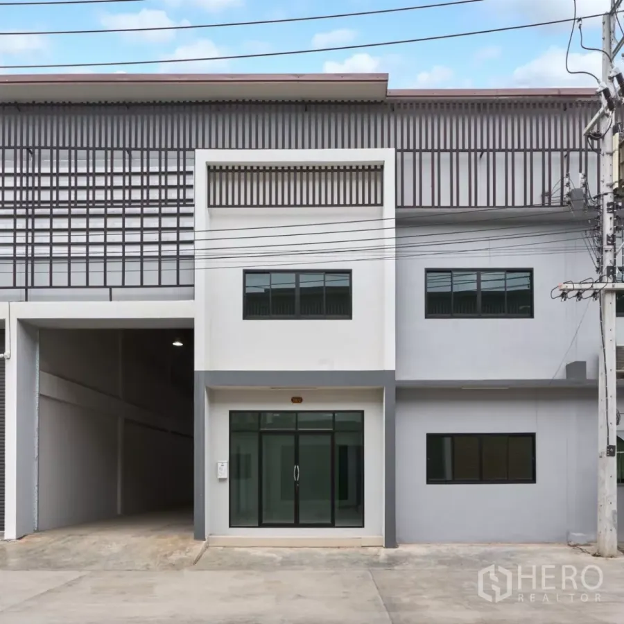 Factory for rent in Mueang Samut Sakhon, Samut Sakhon - Modern two-storey factory facade with glass office entrance and paved forecourt.
