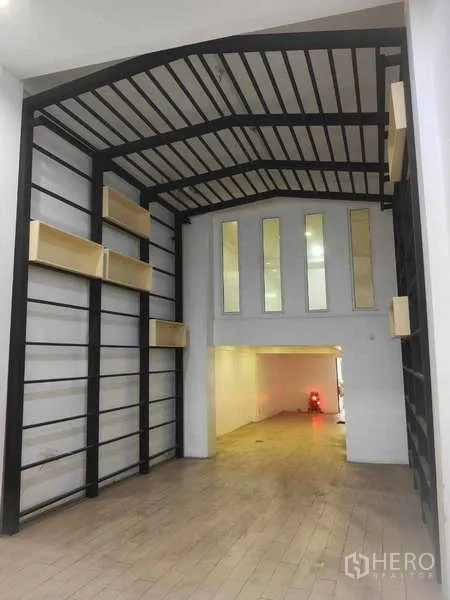 Shophouse for sale in Phra Khanong, Bangkok - Showroom space with steel-frame shelving and loft windows.