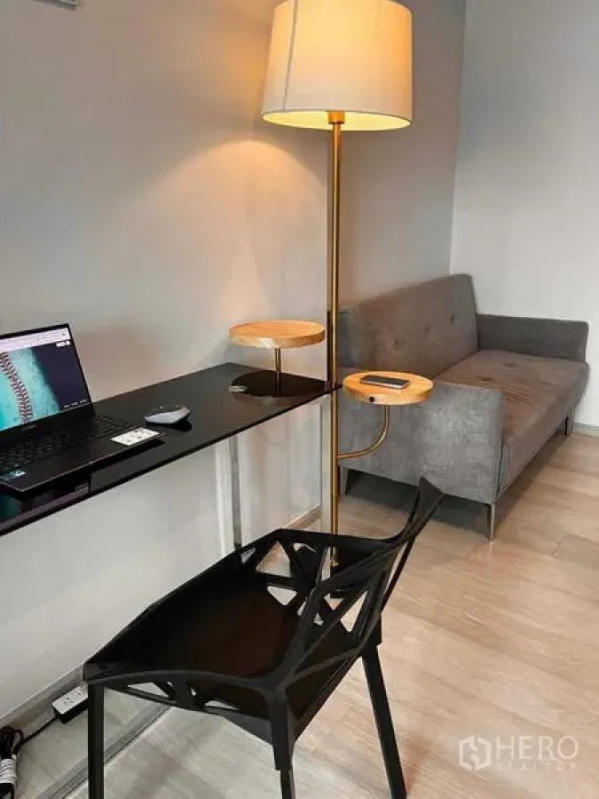 Condominium for rent or sale in Pathum Wan, Bangkok - Work-from-home nook with floor lamp, desk and sofa in the living space.