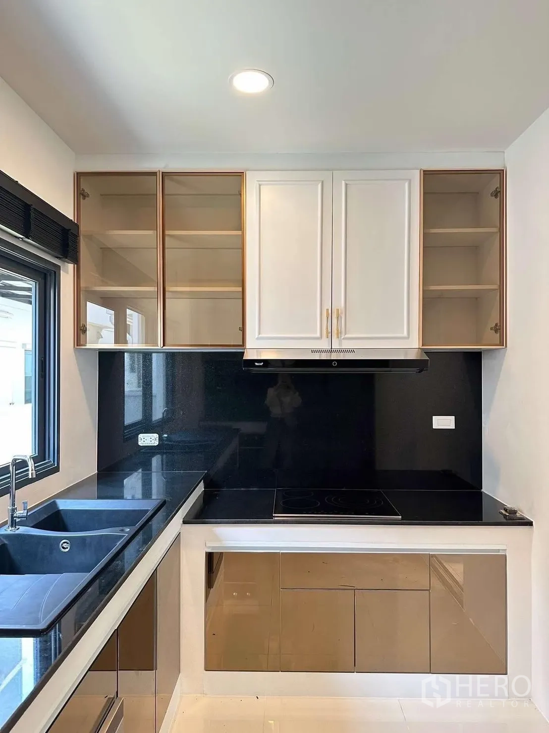 Detached House for rent in Bang Phli, Samut Prakan - Kitchen corner with stovetop, range hood, and double sink under a wide window.