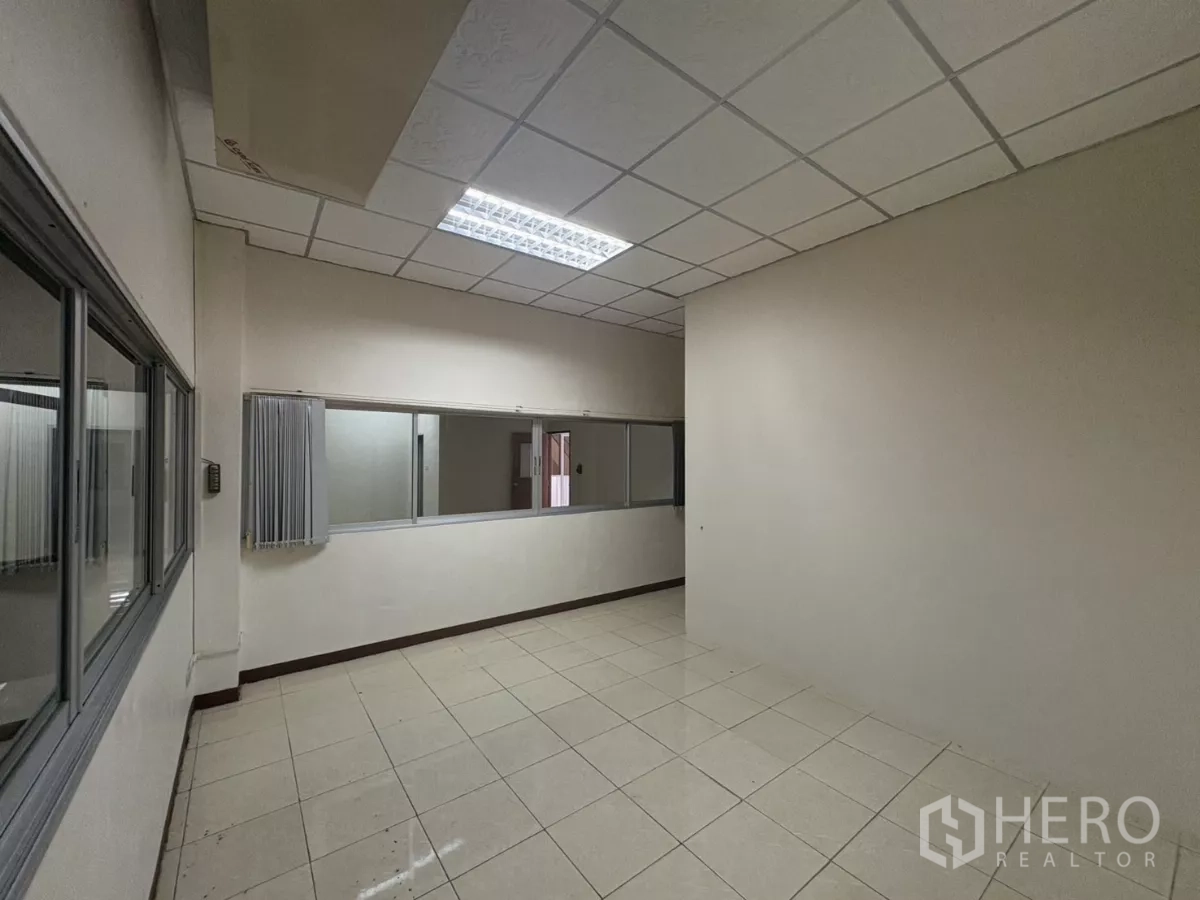 Warehouse for rent in Bang Phli, Samut Prakan - Long corridor-style office with internal glass windows and tiled floor.