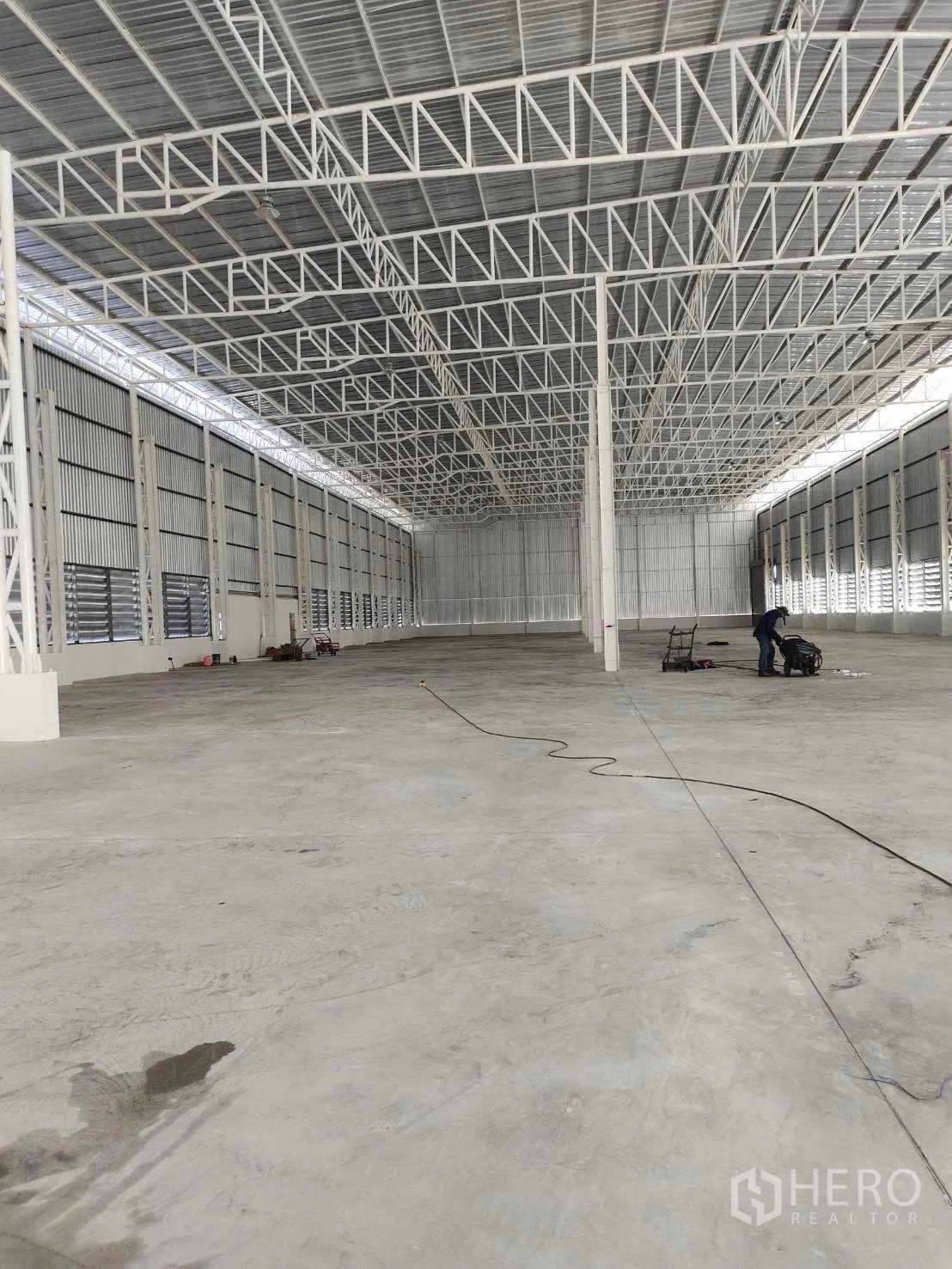 Factory for sale in Nikhom Phatthana, Rayong - Vast warehouse interior with high steel truss roof and concrete floor.