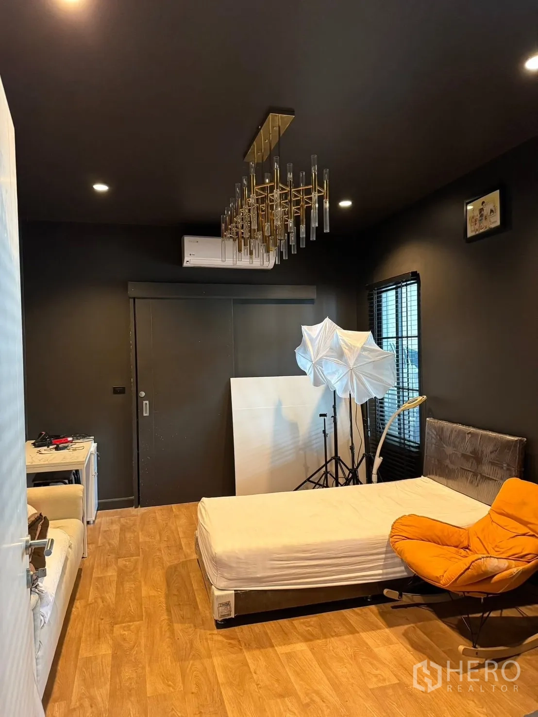 Detached House for sale in Mueang Pathum Thani, Pathum Thani - Another view of the dark bedroom showing bed, chair and windows.