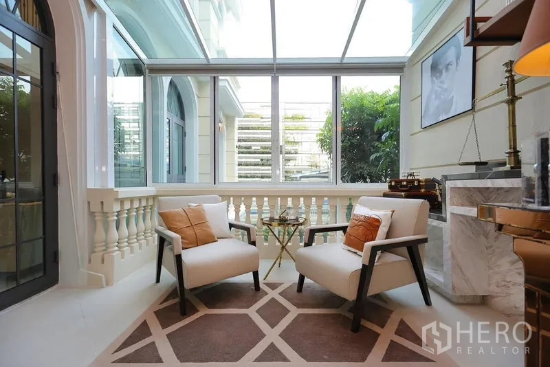 Detached House for rent or sale in Watthana, Bangkok - Enclosed sunroom with glass roof and two lounge chairs.