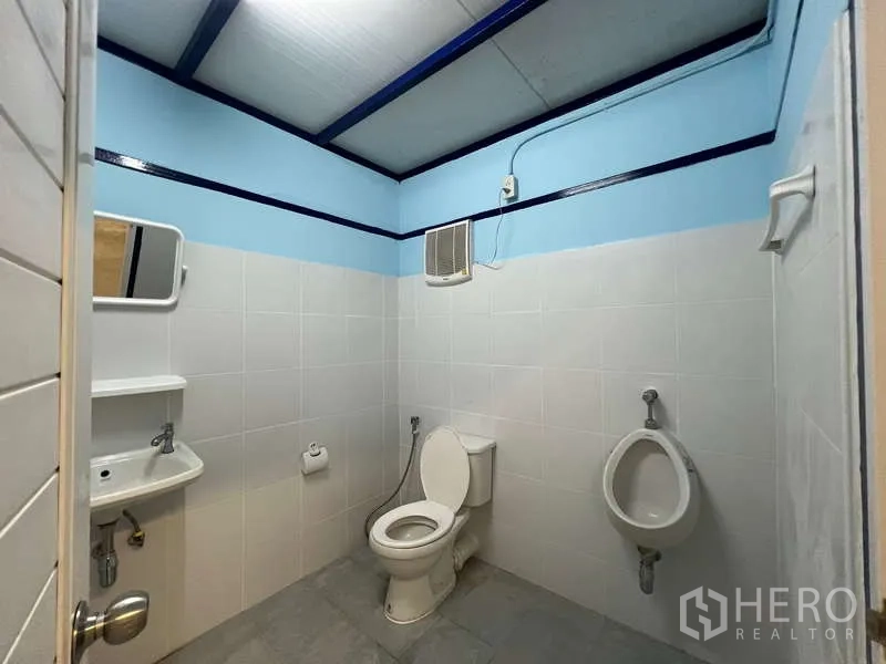 货栈 出租在Lat Krabang, Bangkok - 仓库内整洁的瓷砖卫生间，含坐便器、小便器和洗手盆。