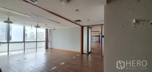 Office Space for rent in Watthana, Bangkok - Bright open-plan office with wooden floors, floor boxes, and full-height windows offering city views.
