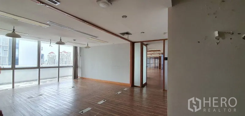 Office Space for rent in Watthana, Bangkok - Bright open-plan office with wooden floors, floor boxes, and full-height windows offering city views.