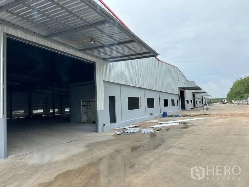 Factory for rent in Rayong - Row of new factory units with multiple roller doors and truck-friendly access road.