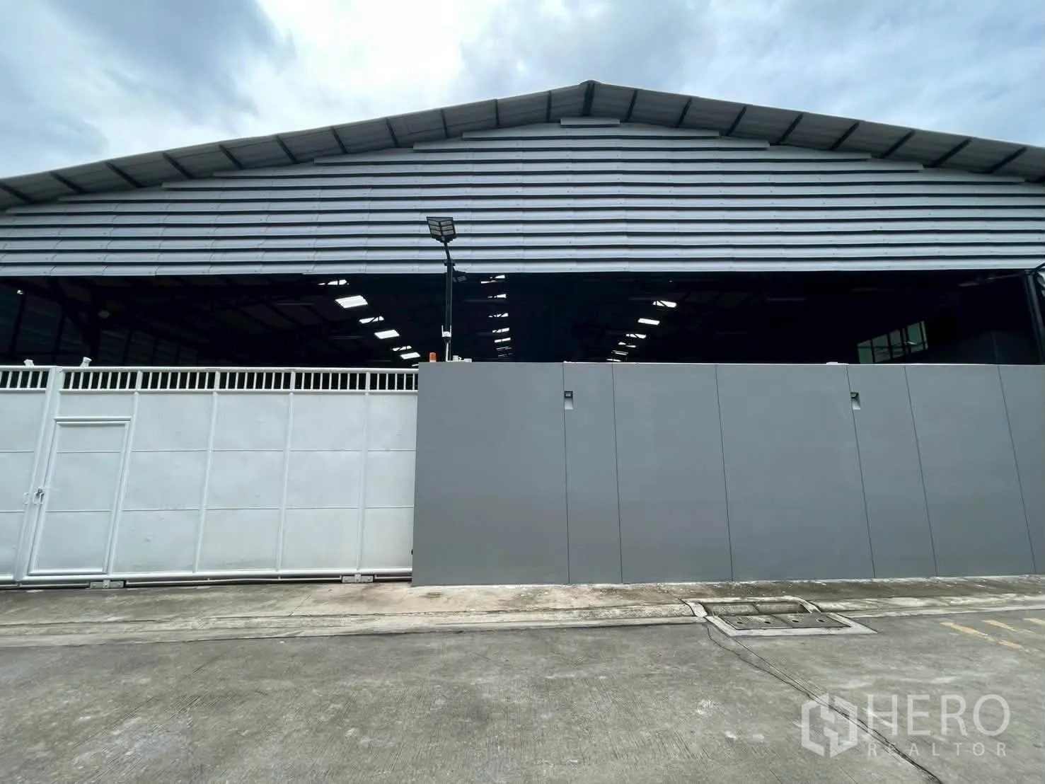 仓库 for rent in Taling Chan, Bangkok - 金属屋顶仓库的正面外观，前方为宽幅推拉门。