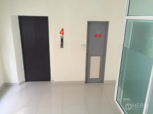 Office Space for rent in Bang Kapi, Bangkok - Elevator lobby with lift and restroom access beside a glass partition wall.
