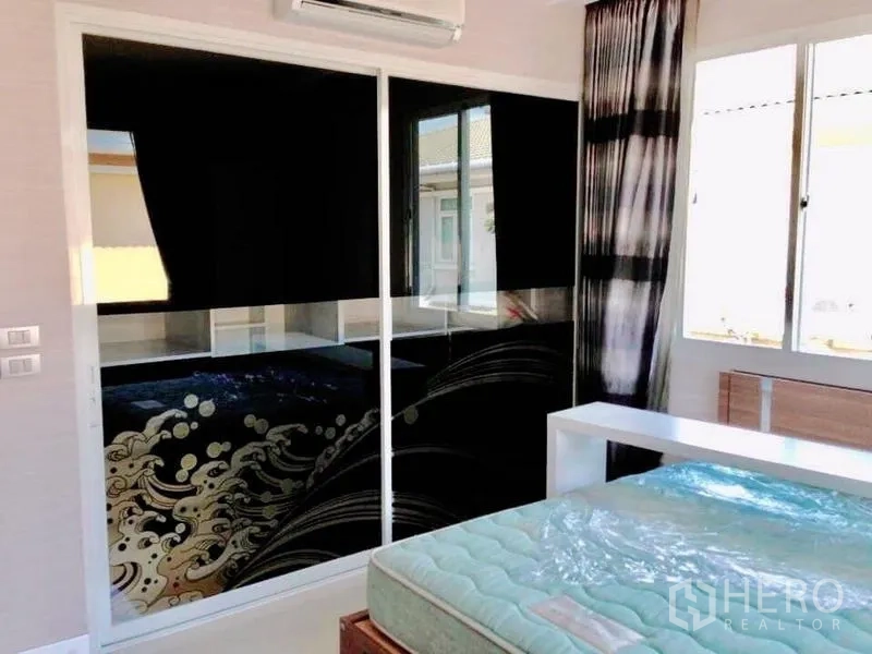 Detached House for rent or sale in Prawet, Bangkok - Bedroom with wide windows and black glass wardrobe featuring wave pattern.