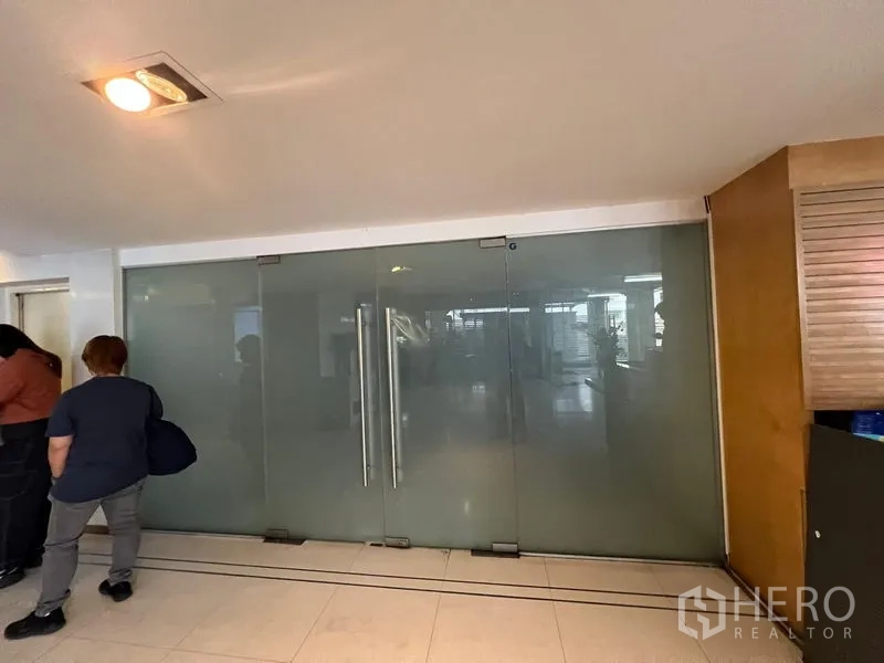 Office Space for rent - Glass-fronted office entrance with long pull handles in a commercial corridor.