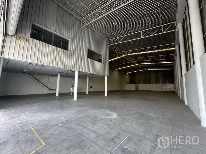 工厂 出租在Khlong Luang, Pathum Thani - 仓库内部空间开阔，层高高，钢结构屋架，带夹层办公室与楼梯。
