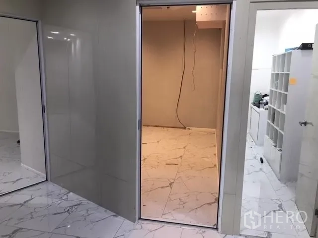 Retail Space for rent in Watthana, Bangkok - Partitioned room with sliding door beside a back-of-house utility area with shelving.