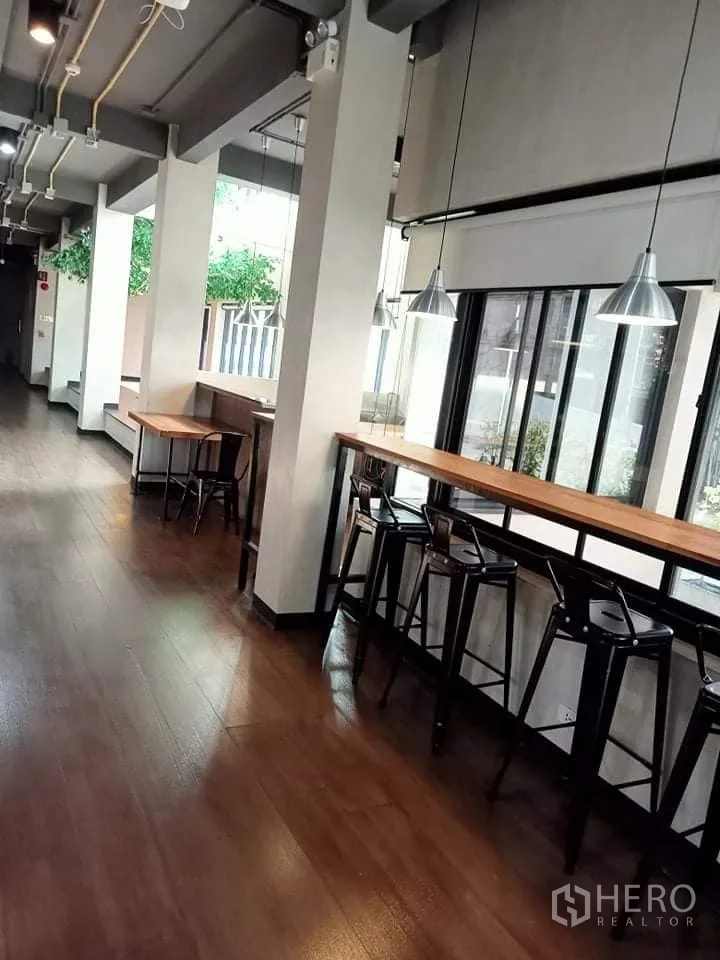 Office Space for rent in Phra Khanong, Bangkok - Window-side work counters with high stools, pendant lights and wood floors in a bright office