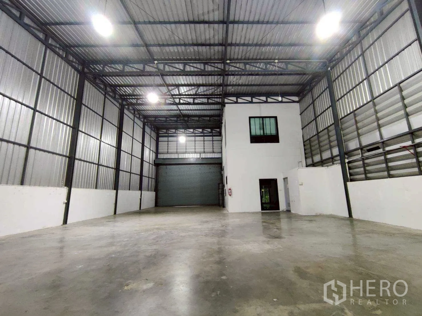 仓库 for rent in Lam Luk Ka, Pathum Thani - 开阔的存储区，正对大型卷闸门和两层办公区。
