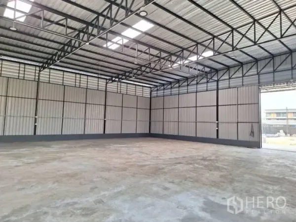 Warehouse for rent in Wang Thonglang, Bangkok - Spacious warehouse interior featuring high steel truss roof, skylights and smooth concrete floor.