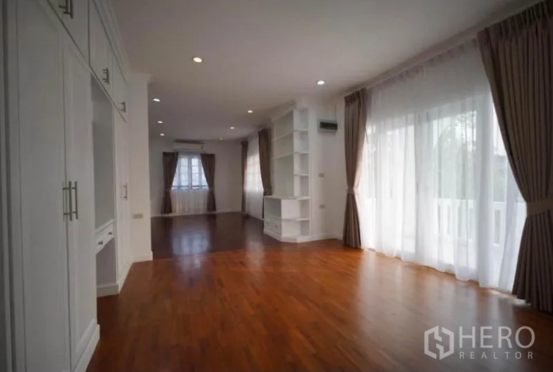 Detached House for rent in Bang Phli, Samut Prakan - Bright master bedroom with balcony access, built-in wardrobes and curtains.